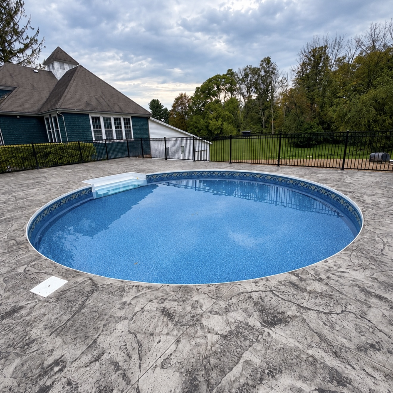 Latham inground pool with a paved poolside area